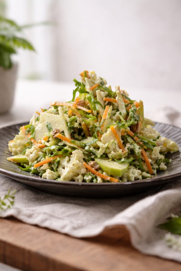 Fresh seasonal salad with raw cauliflower, green apple, carrot and yogurt dressing